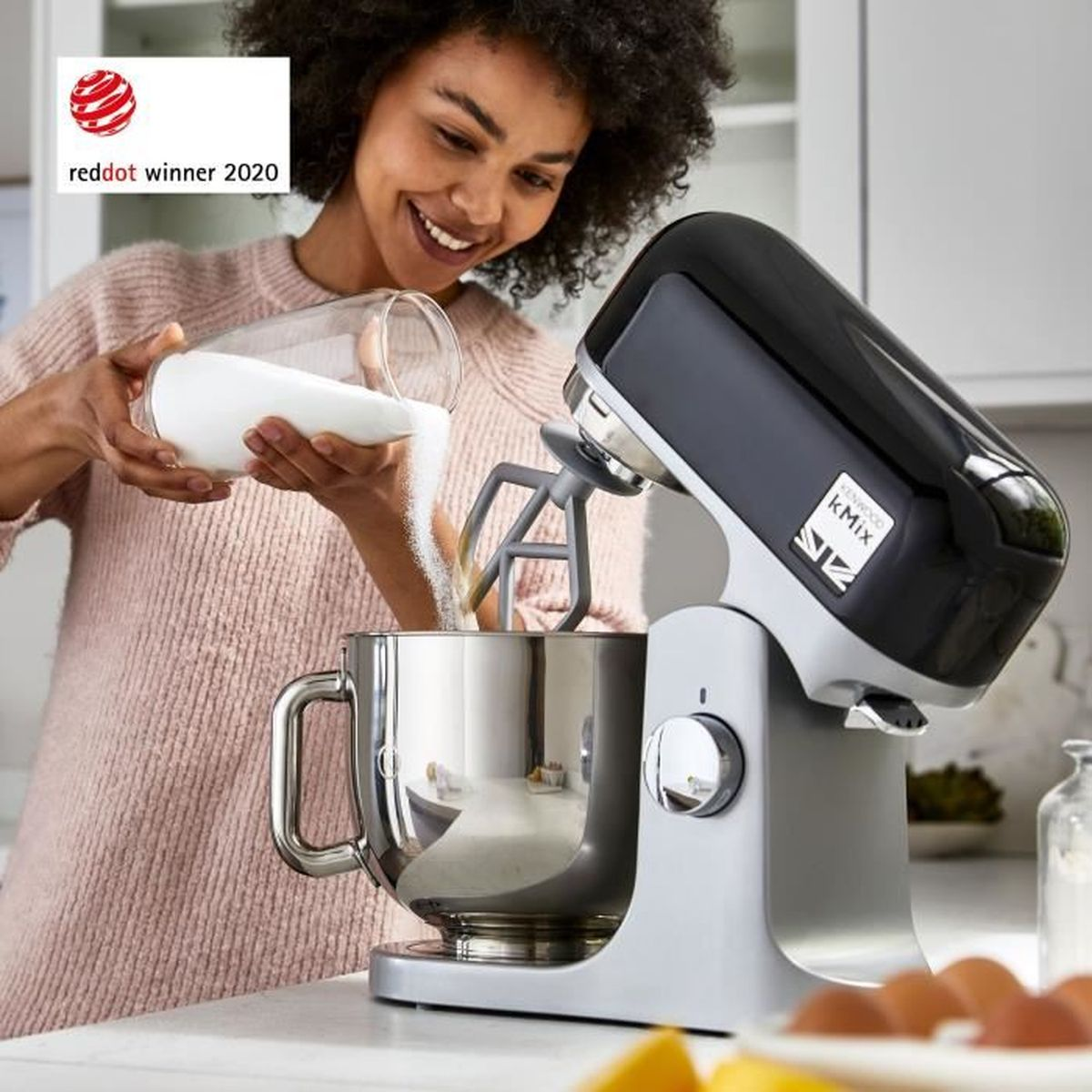 Eine Frau gießt Zucker in eine Küchenmaschine. Red Dot Award 2020.