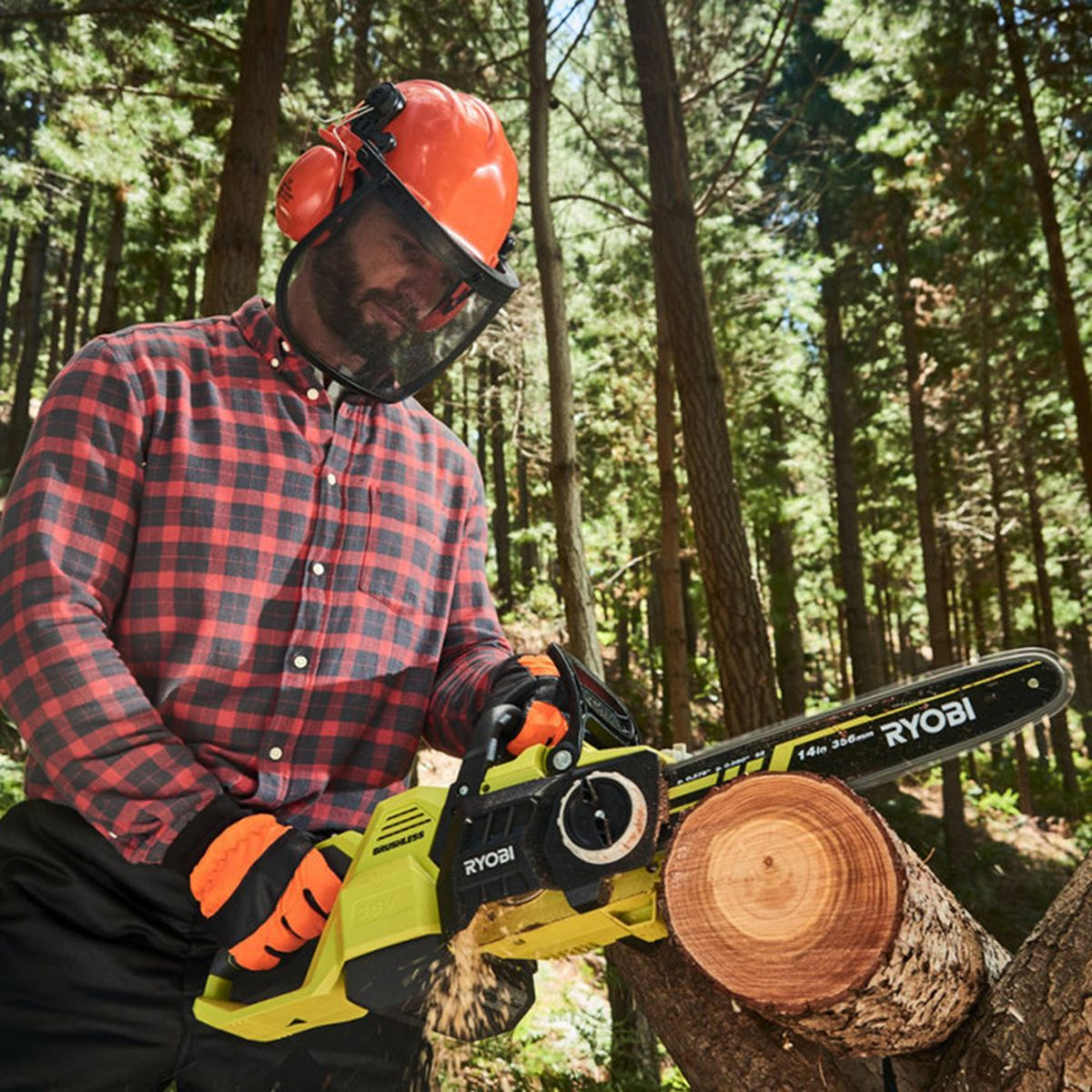 Mann mit orangefarbenem Helm und Schutzbrille schneidet Holz mit Kettensäge.