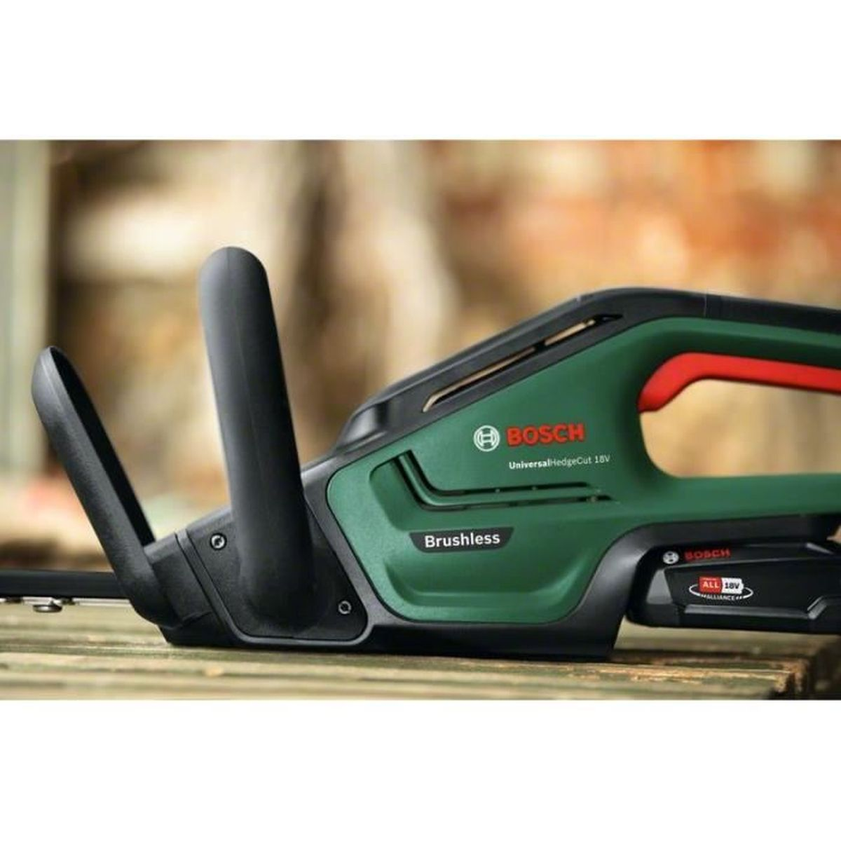 Cortasetos inalámbrico Bosch verde con mango rojo sobre superficie de madera.