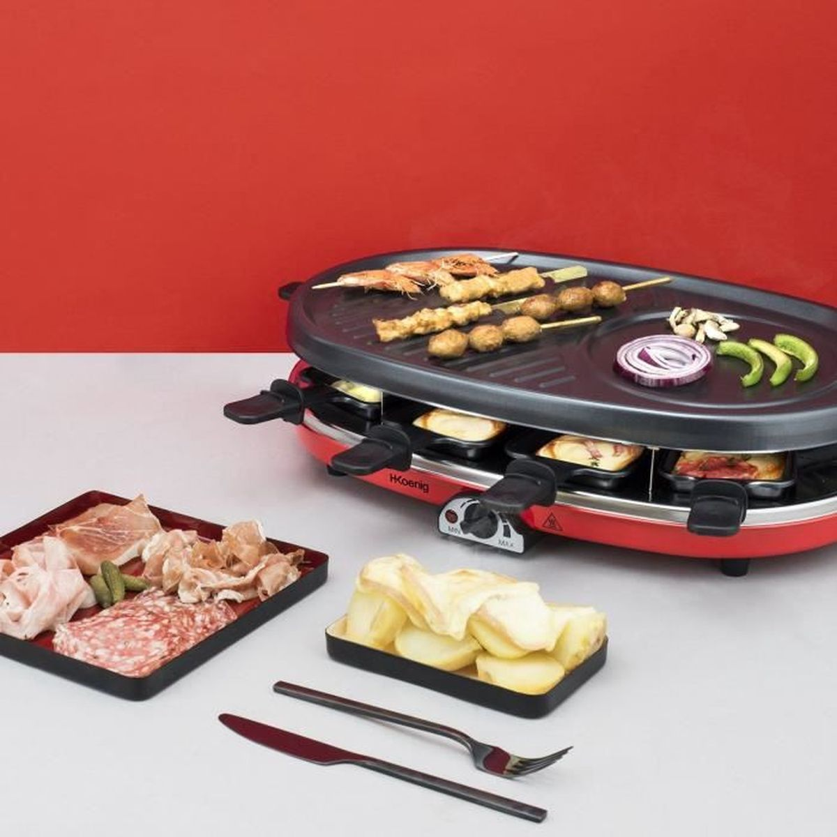Czerwony grill raclette z szaszłykami, mięsem, serem i warzywami.