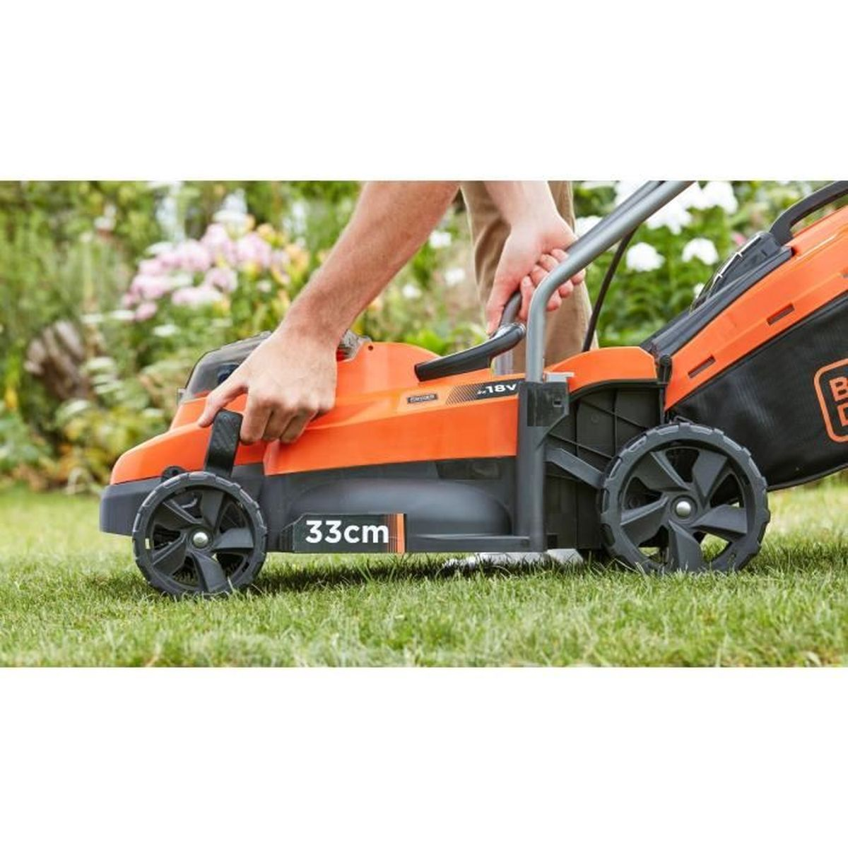 Ein Mann schiebt einen orangefarbenen Rasenmäher über grünes Gras.