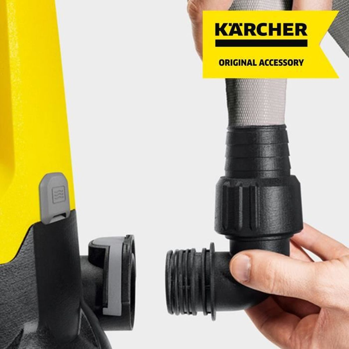Macchina Karcher gialla con raccordo nero tenuto da una mano.
