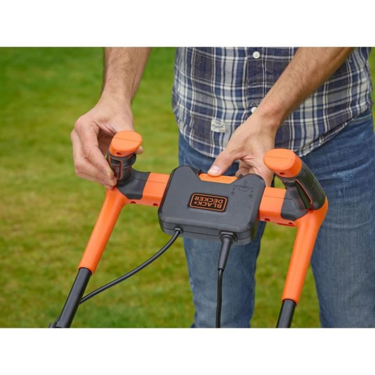 Mann mit blau kariertem Hemd hält orangefarbenen Rasenmähergriff im Gras.