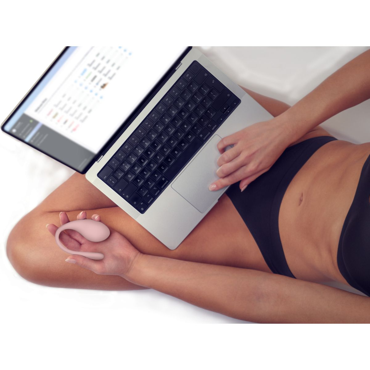 Eine Person hält einen rosafarbenen Vibrator und benutzt einen Laptop.
