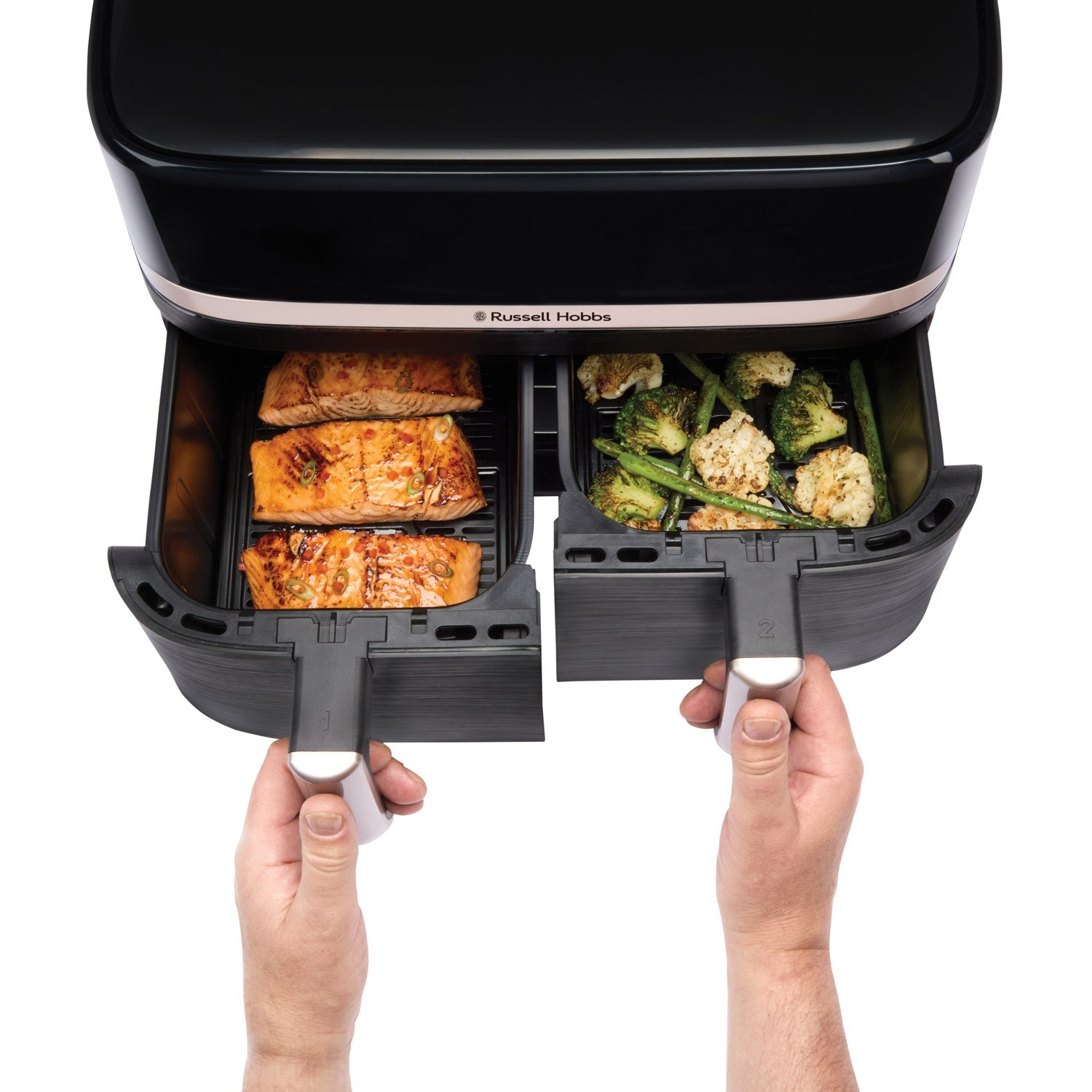 Dwie szuflady czarnej frytownicy beztłuszczowej z gotowanym łososiem i warzywami.