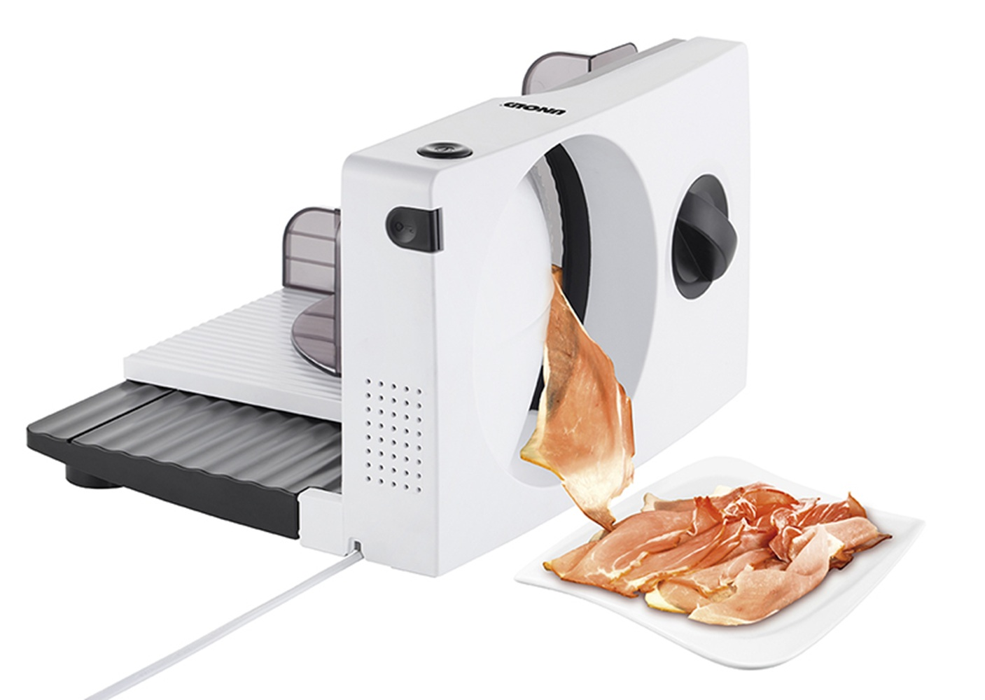 Biała krajalnica do mięsa z cienko pokrojonym szynką na talerzu obok.