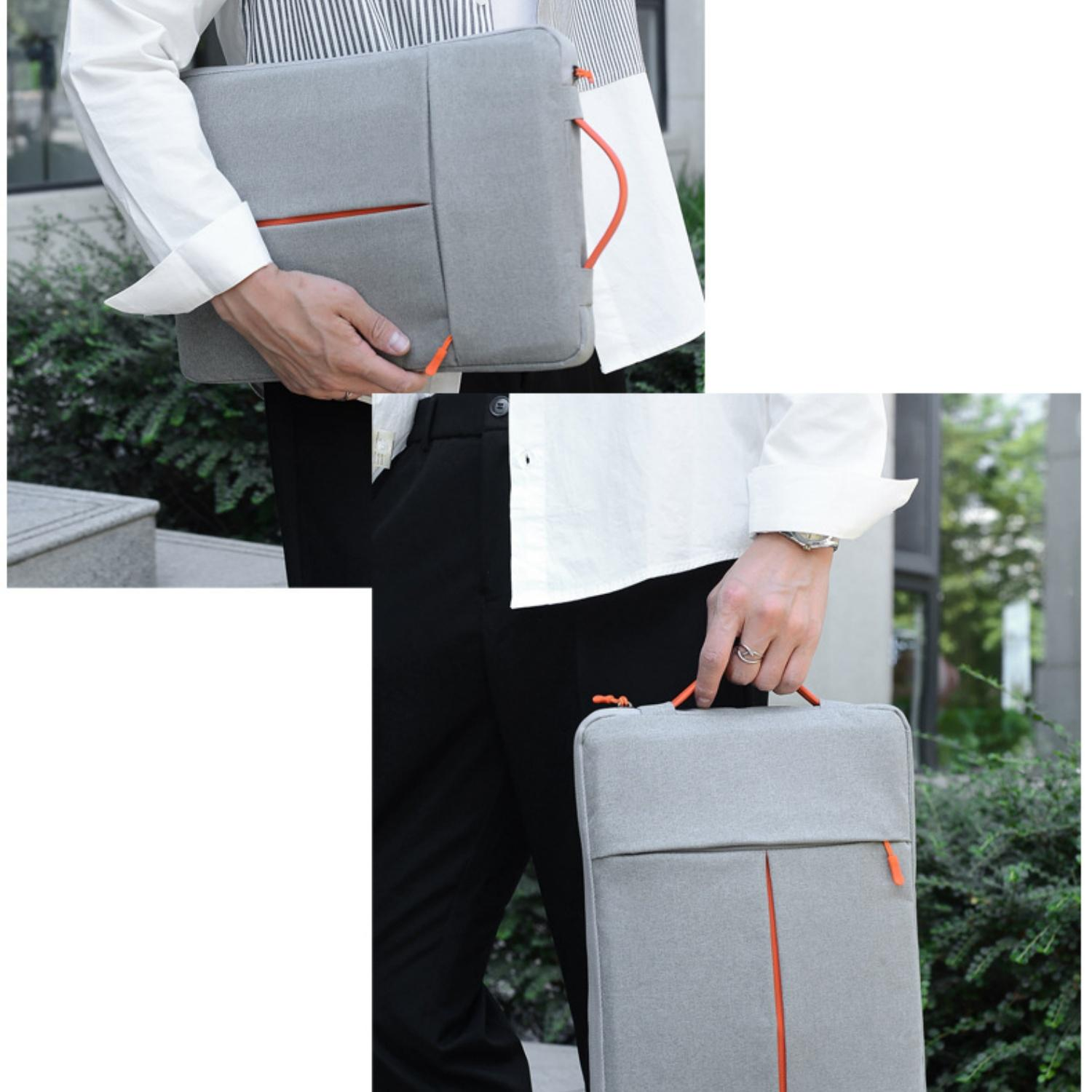 Graue Laptoptasche mit orangefarbenen Akzenten, von einer Person gehalten.