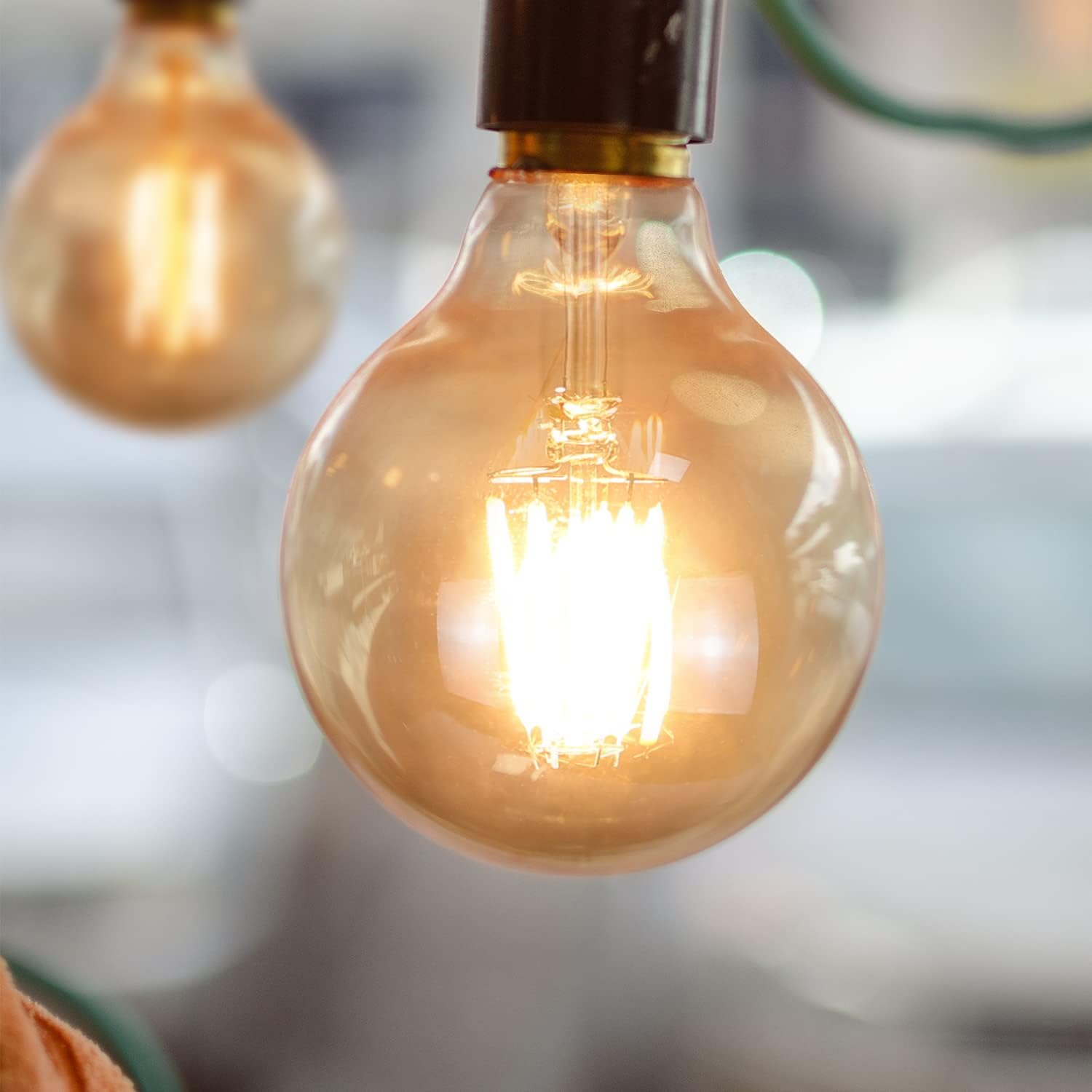 Lampadina Edison luminosa con filamento visibile e sfondo sfocato.