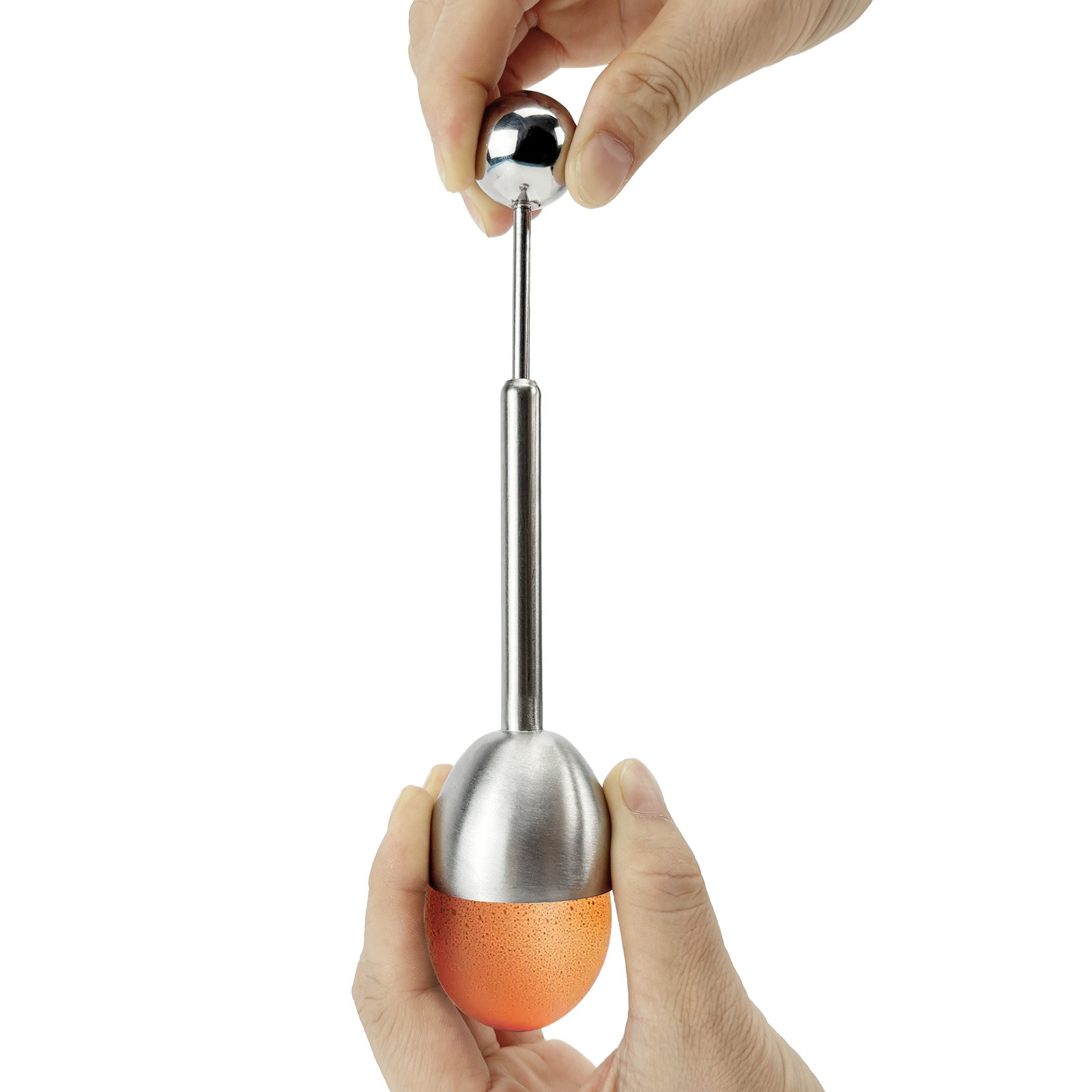 Hands holding an egg topper over an orange egg.