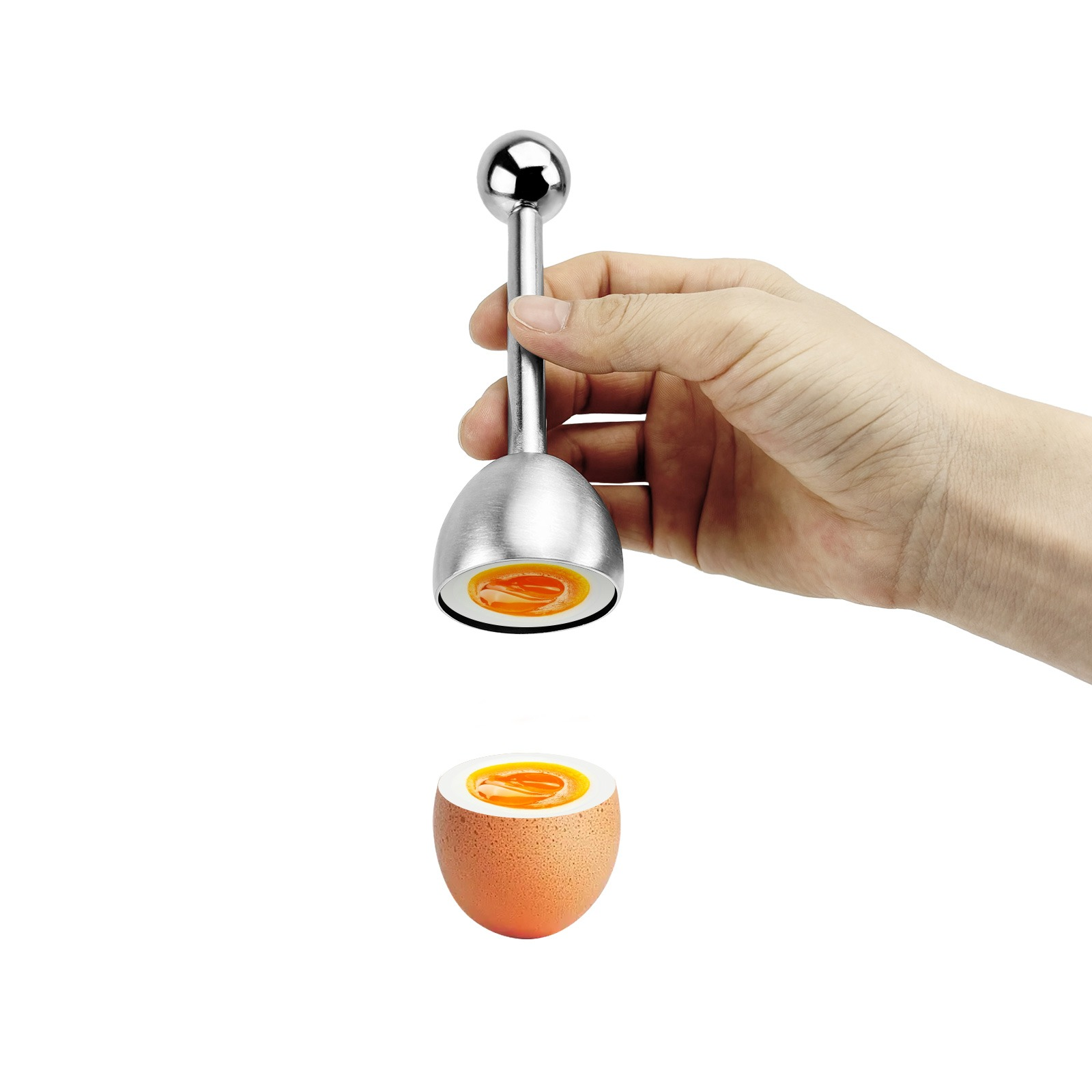 A silver egg topper is held above a halved egg. The yolk is runny.