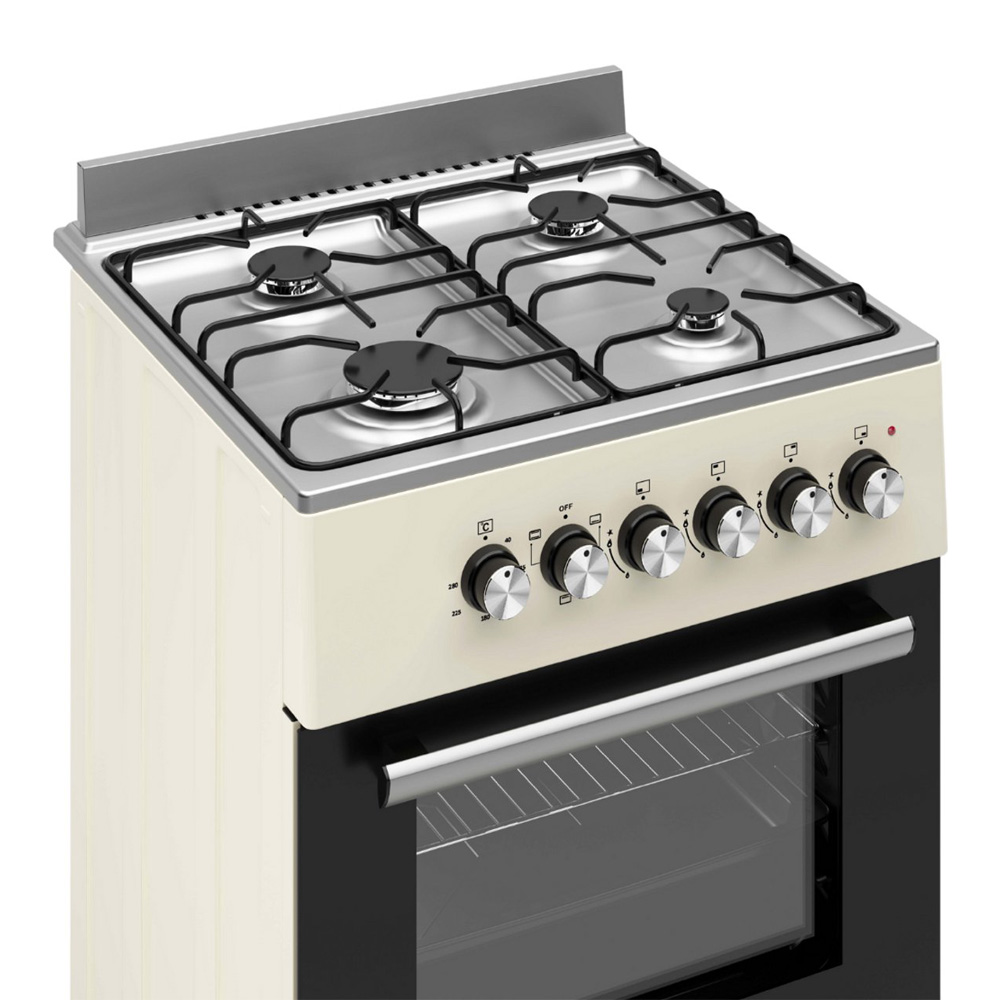 Une cuisinière à gaz crème avec quatre brûleurs, des boutons argentés et un four.