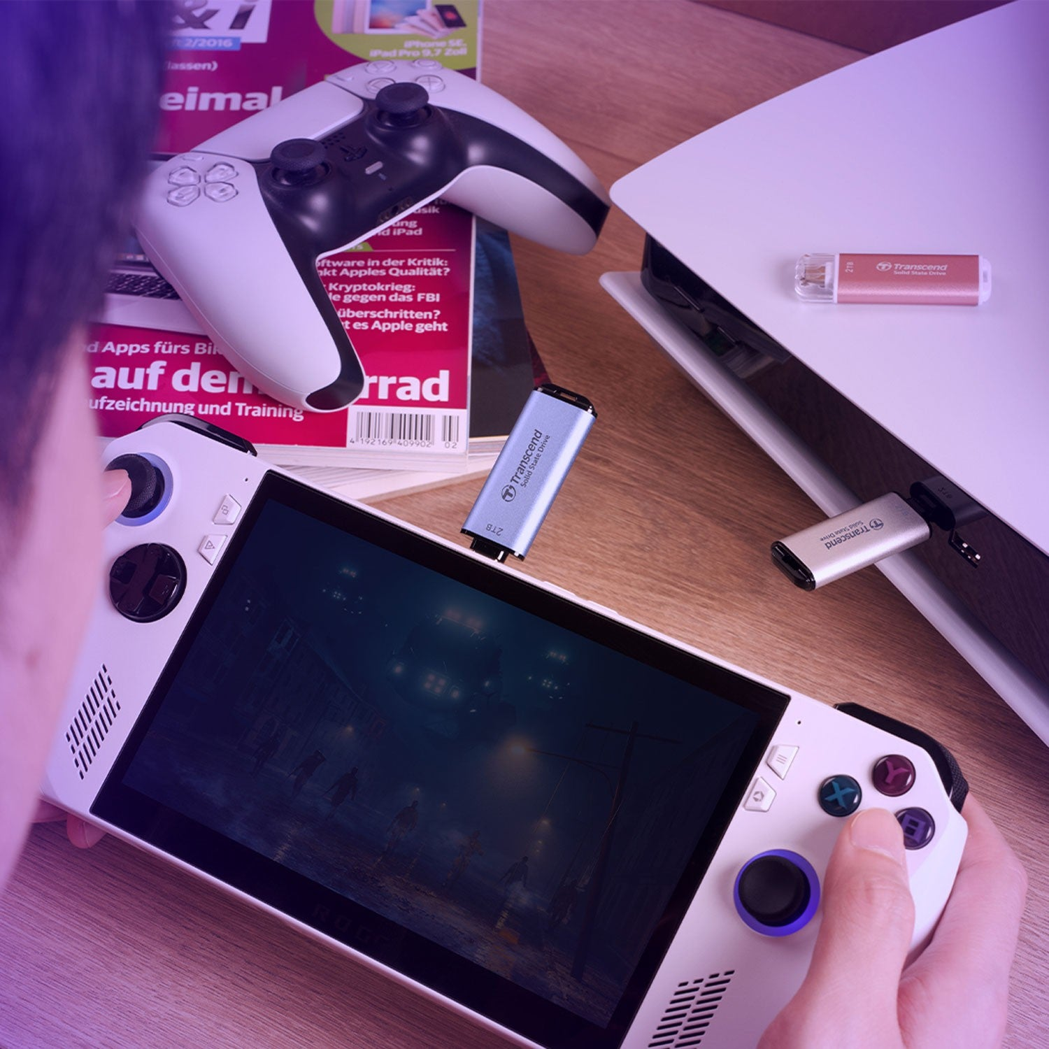 Konsola przenośna, kontroler, konsola do gier i pendrive'y na drewnianym stole.