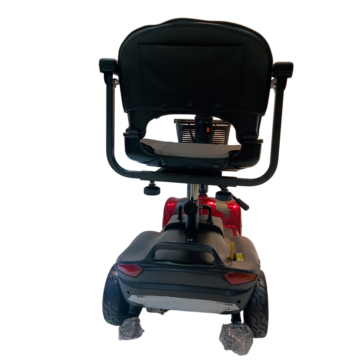 Widok z tyłu czerwonego skutera inwalidzkiego z czarnym siedzeniem i koszem.