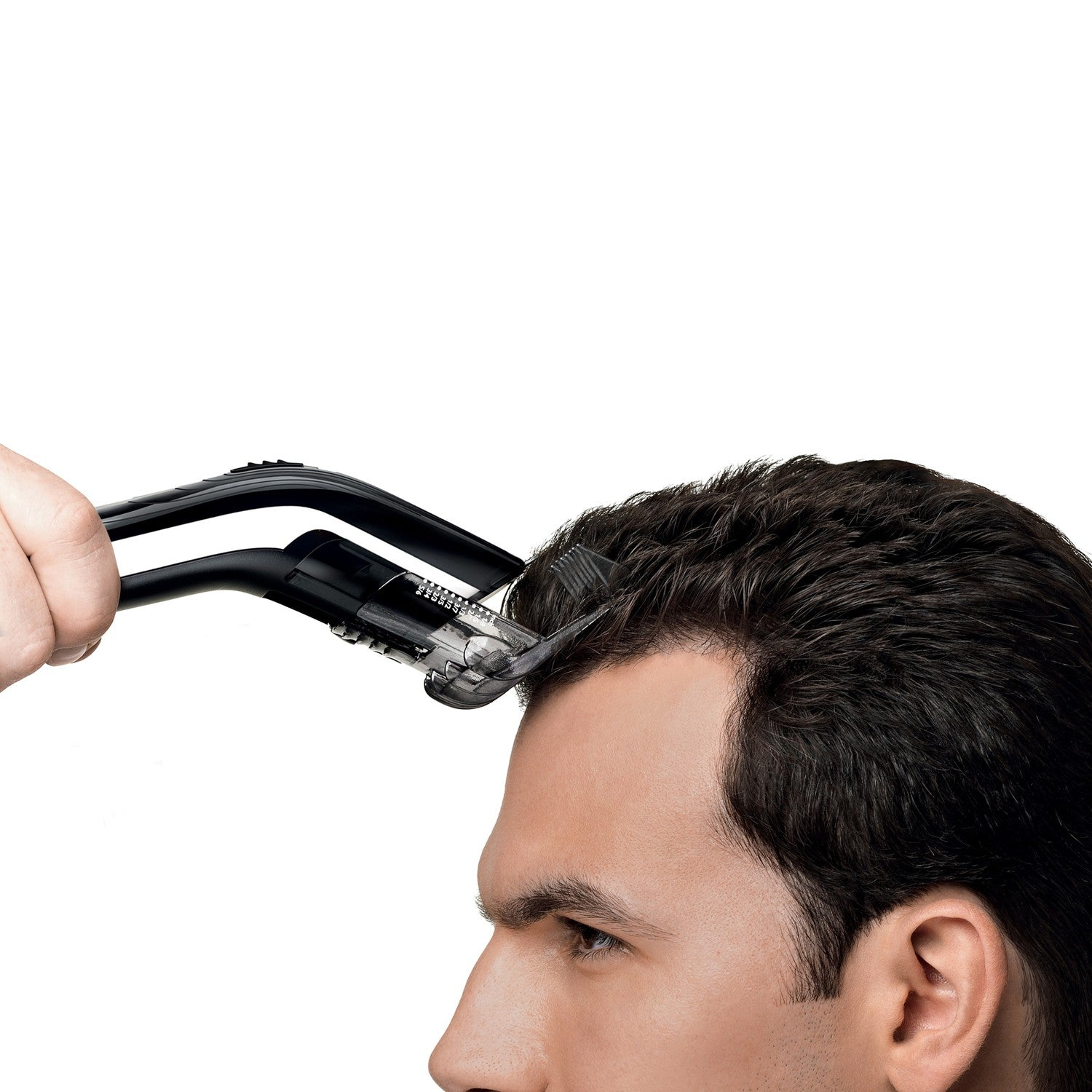 Un hombre se corta el pelo con una cortapelos eléctrica.