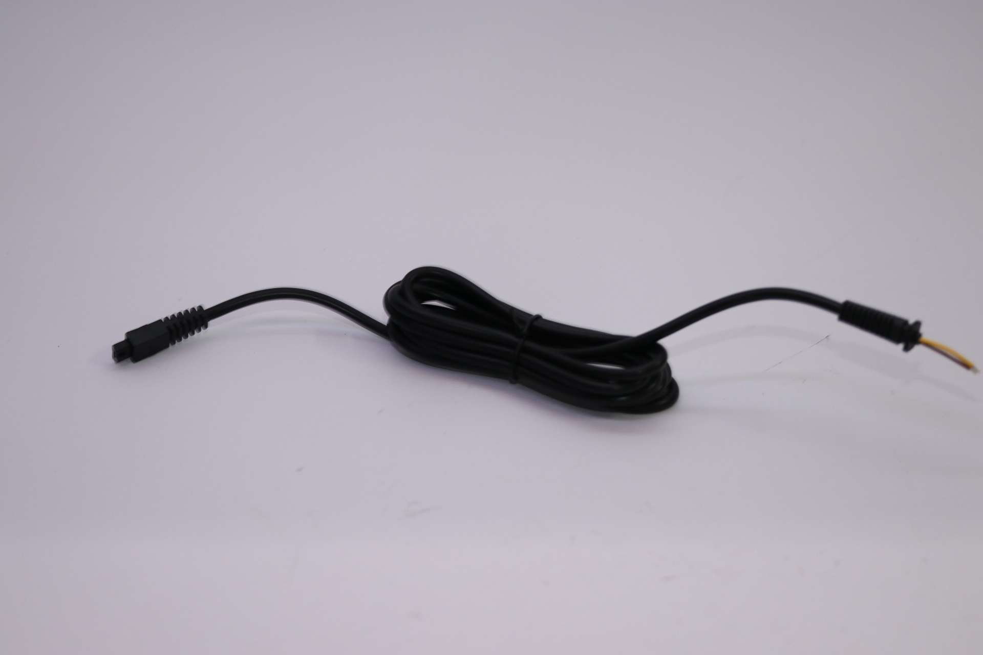 Ein schwarzes Kabel mit einem Stecker und blanken Drähten am anderen Ende.