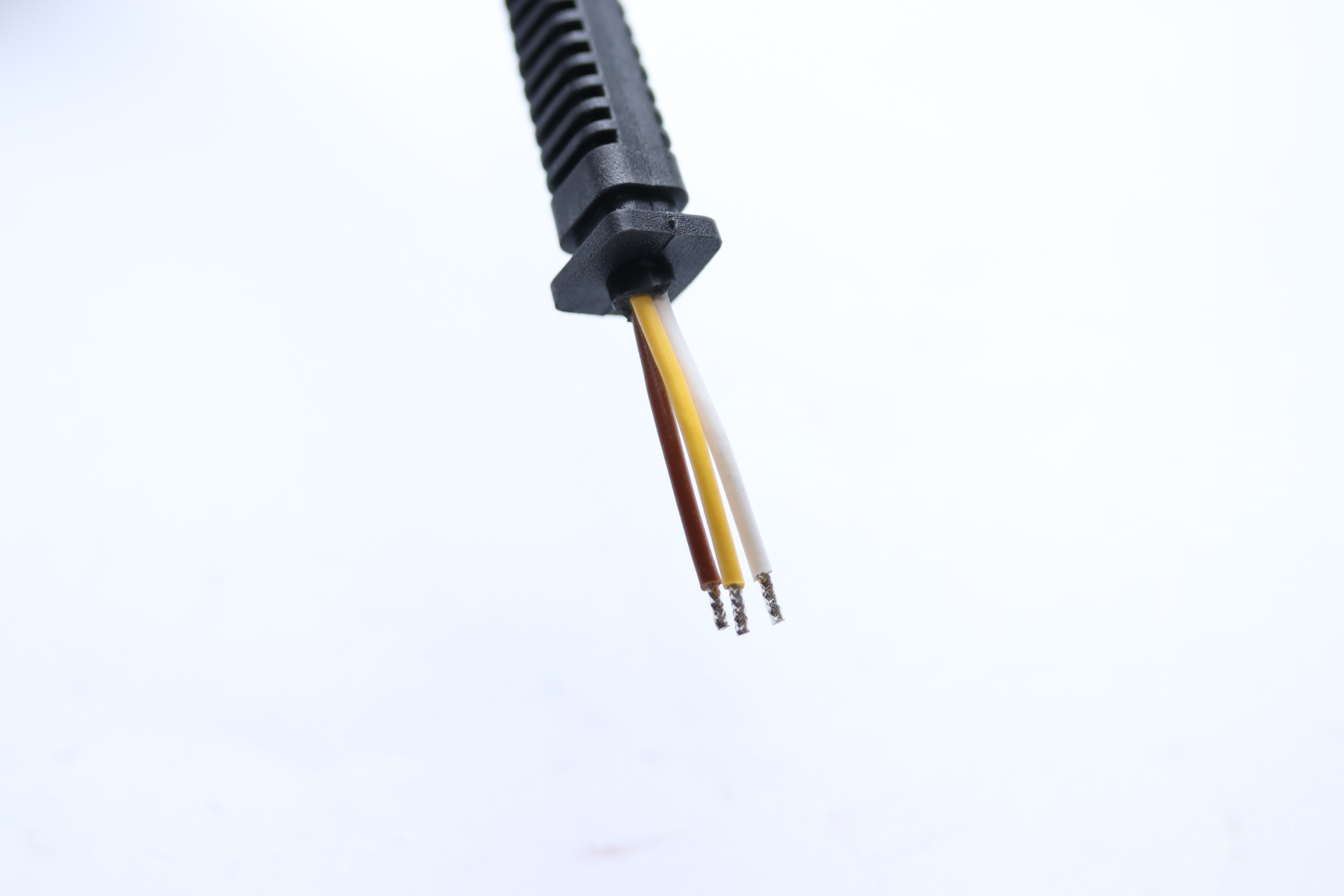 Schwarzer Stecker mit drei freiliegenden Kabeln: braun, gelb und weiß.