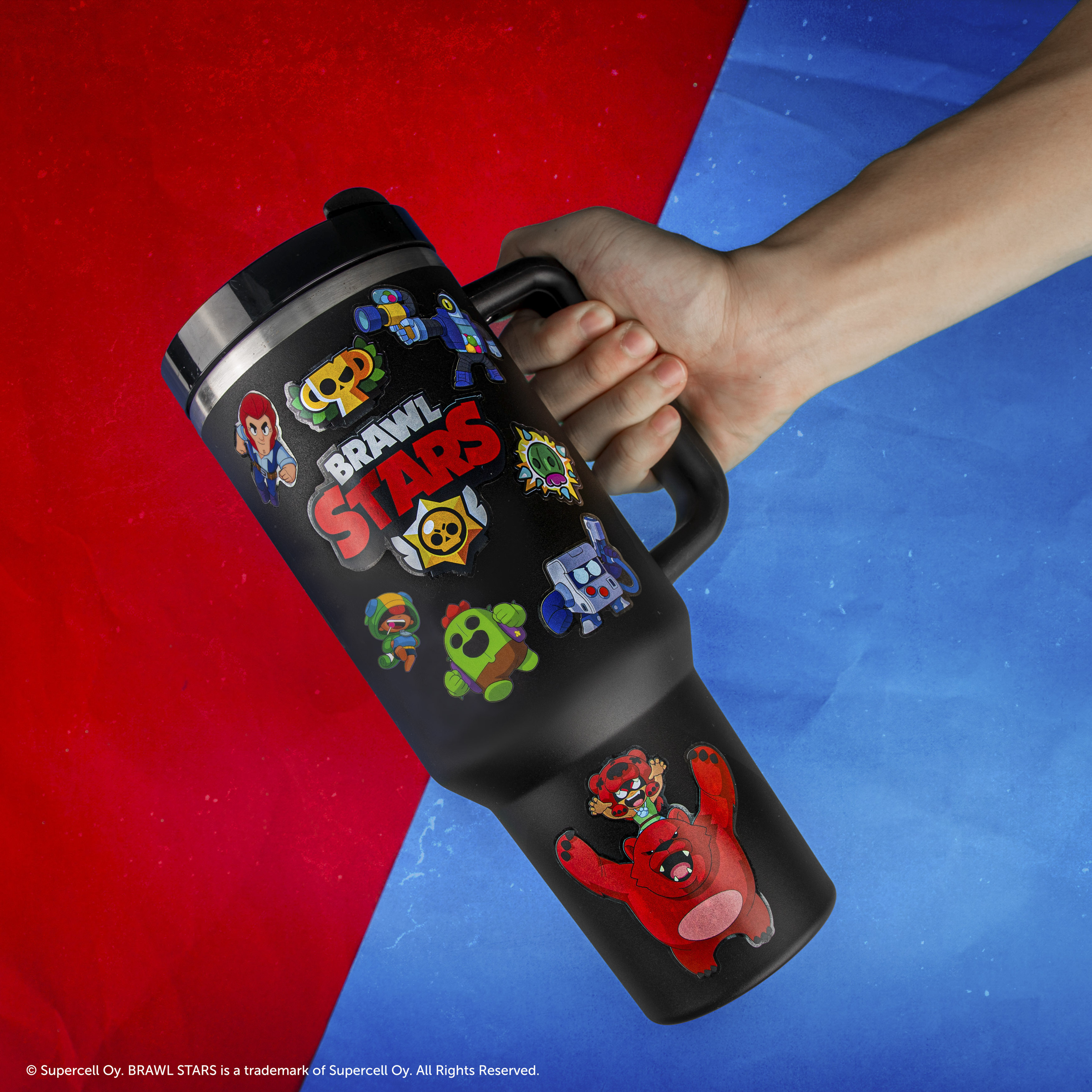 Schwarzer Becher mit Brawl Stars-Aufklebern, gehalten von einer Hand.