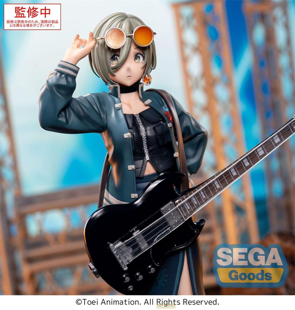 Eine Figur mit Gitarre und Sonnenbrille, im Hintergrund unscharfe Gebäude.