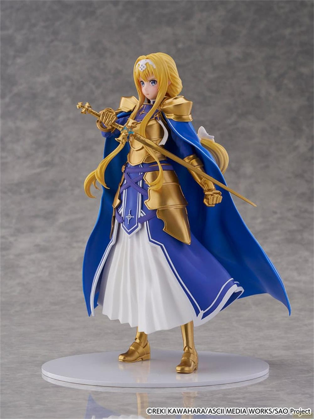 Eine Figur mit blonden Haaren in goldener Rüstung, blauer Robe und weißem Rock, die ein Schwert hält.