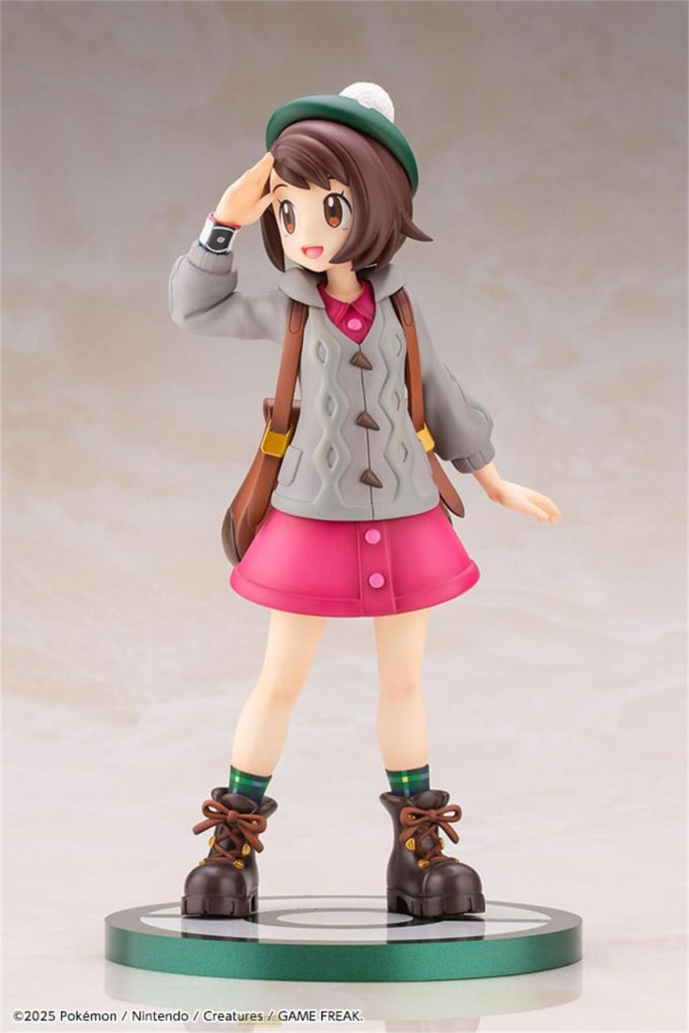 Figura di ragazza con capelli castani, cappello verde, cardigan grigio, gonna rosa e stivali.
