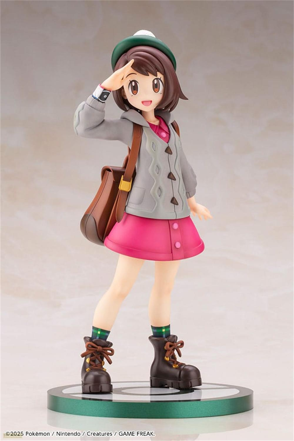 Figura di ragazza con capelli castani, cappello verde e maglione grigio.
