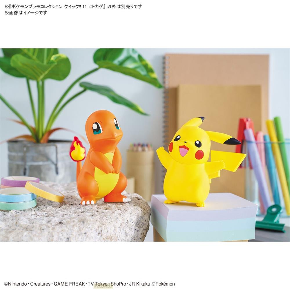 Charmander und Pikachu Figuren auf einem Stein und Stapel Papier.