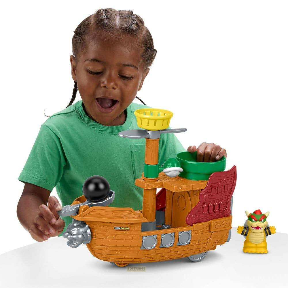 Ein Kind spielt mit einem Piratenschiff-Spielzeug und einer Bowser-Figur.