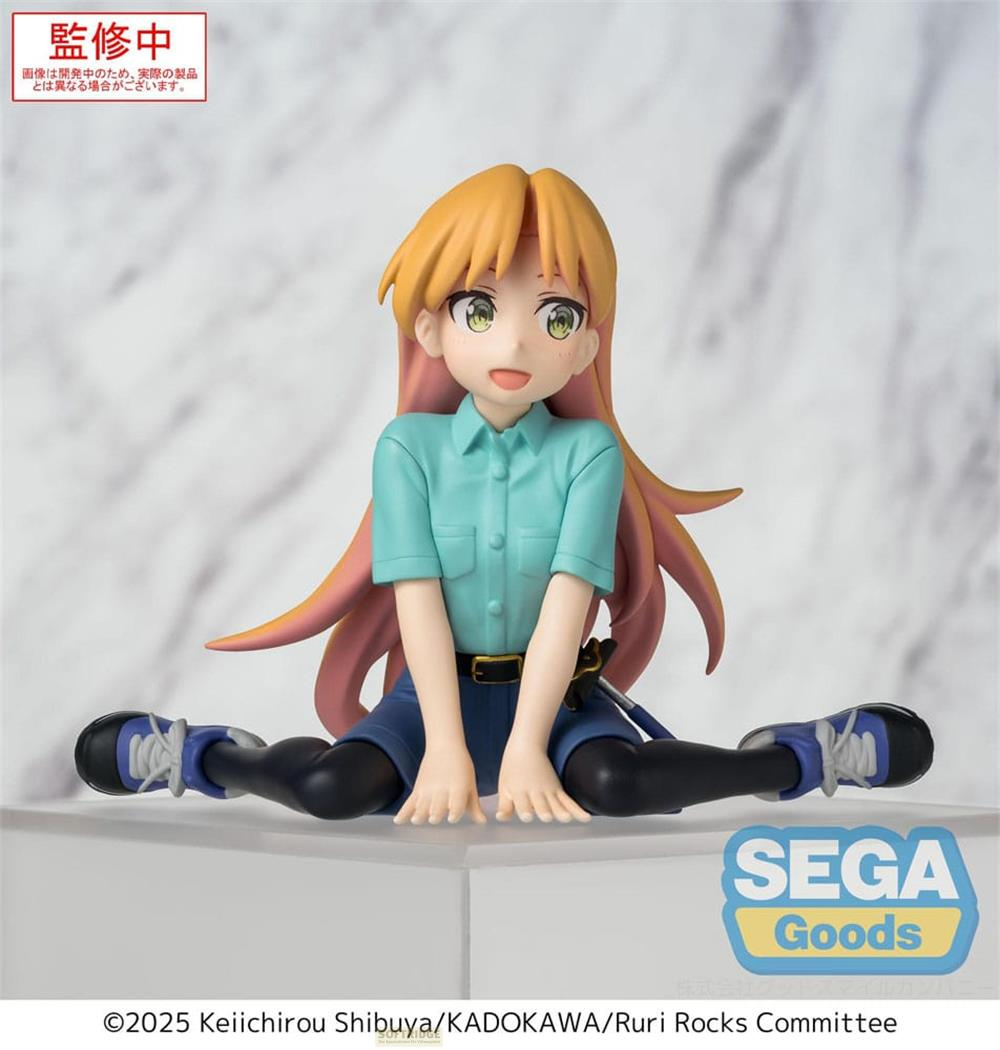 Anime-Figur von einem Mädchen mit orangem Haar in blauem Hemd und Shorts, sitzend mit gespreizten Beinen.