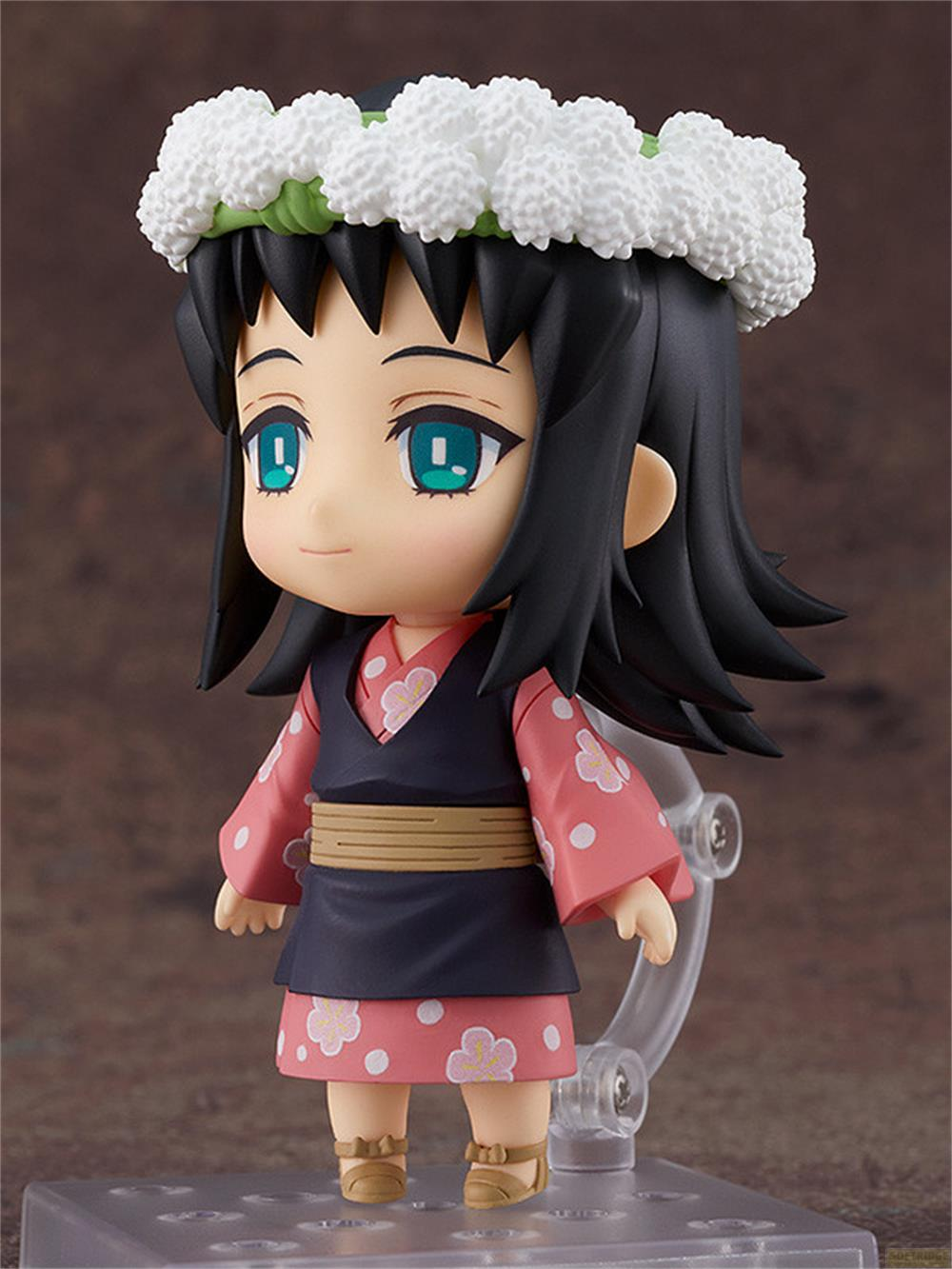 Una figura con capelli neri, una corona di fiori bianchi e un kimono rosa e blu.