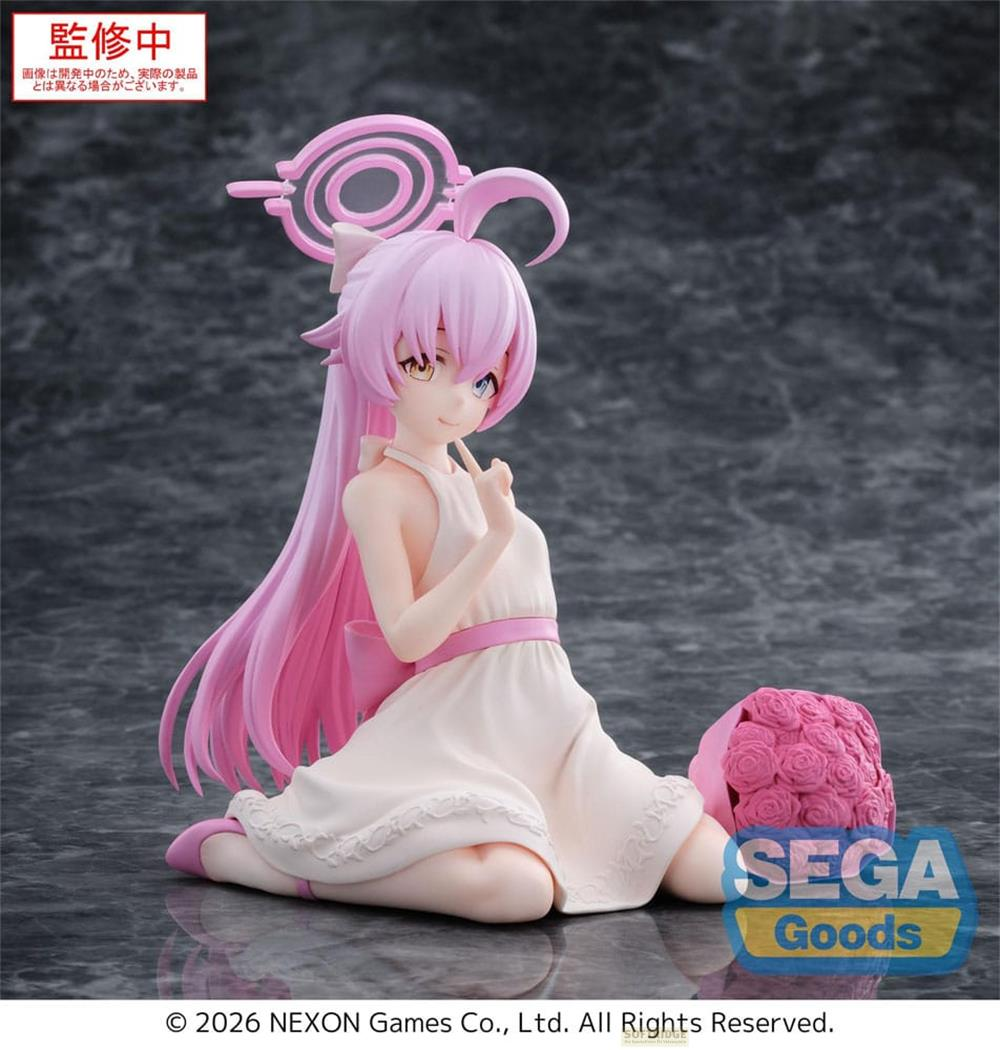 Eine rosa Figur in einem Kleid sitzt neben Rosen.