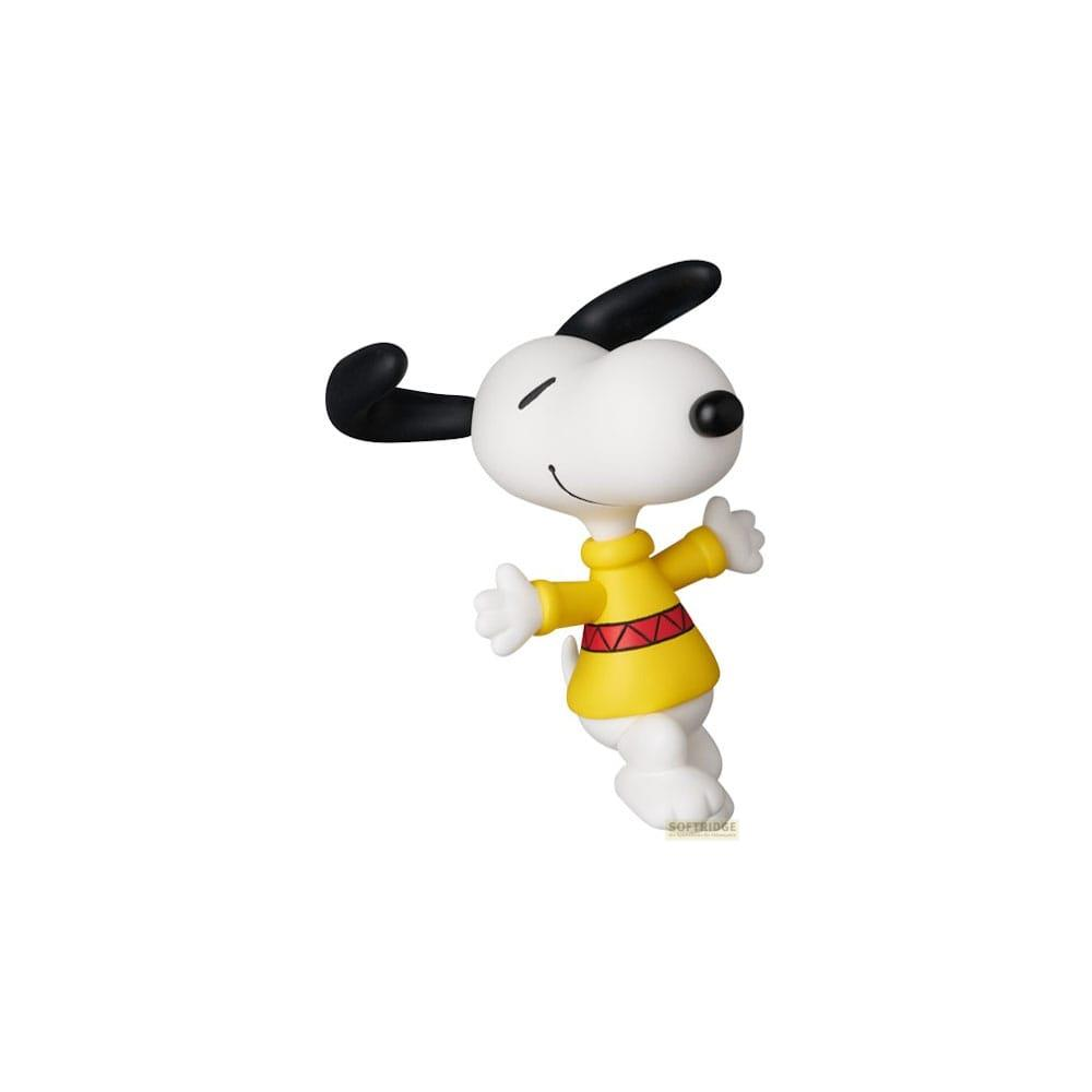 Snoopy in einem gelben Pullover mit rotem Zickzackmuster steht da.