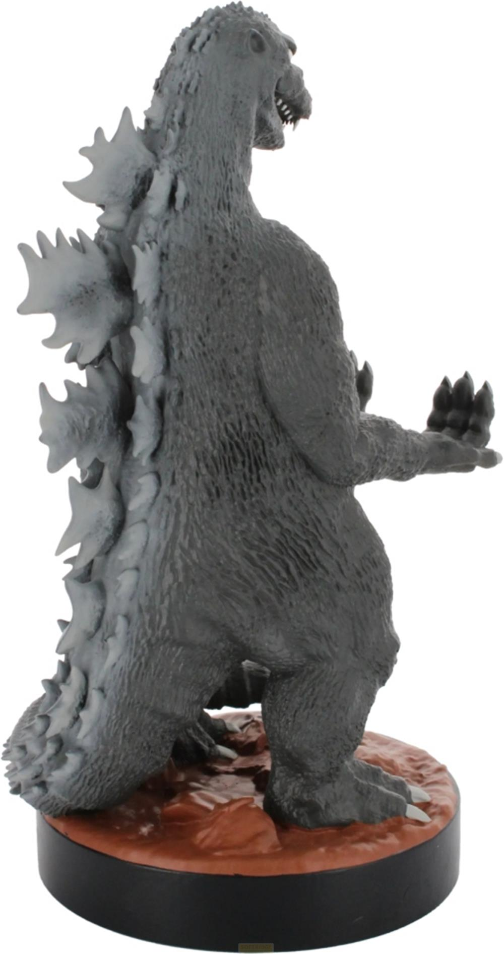 Graue Godzilla-Figur mit Rückenstacheln, die auf braunem Boden steht.