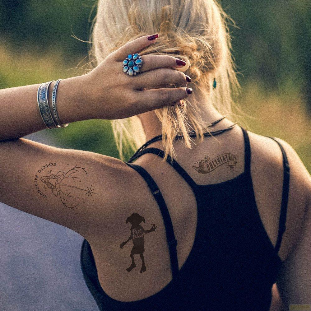 Une femme aux cheveux blonds porte un top noir avec des tatouages d'Harry Potter sur le bras et le dos.