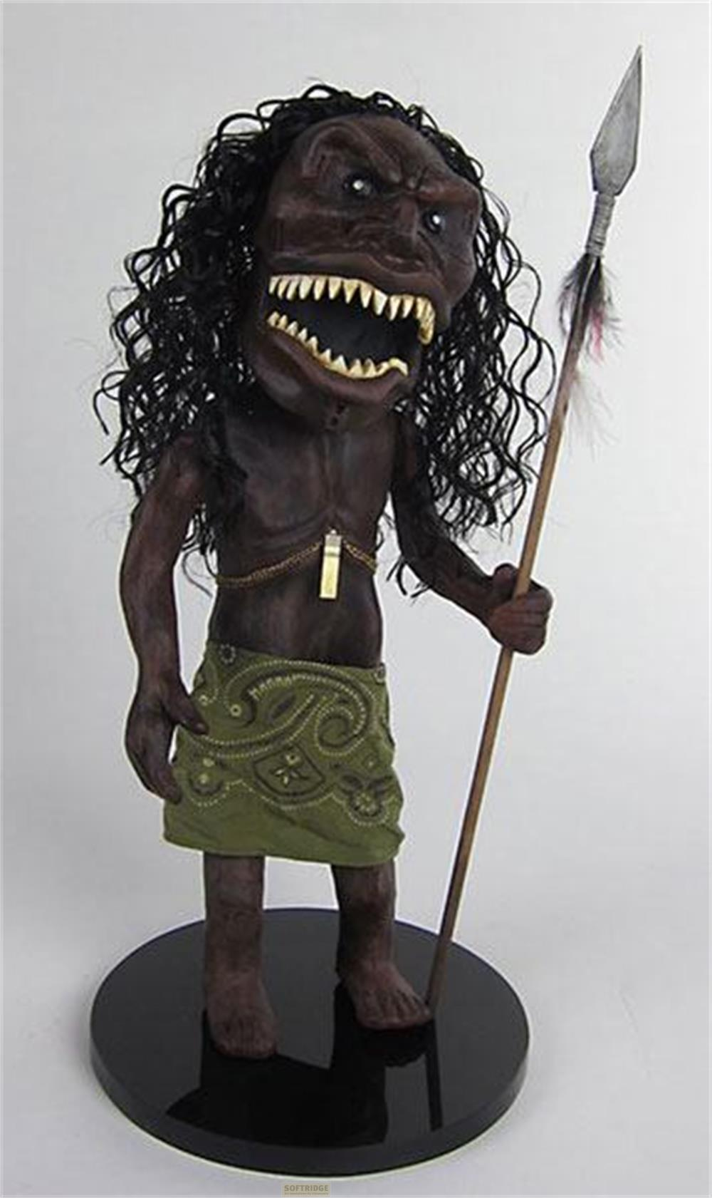 Eine dunkle Figur mit langen schwarzen Haaren und einem Speer.