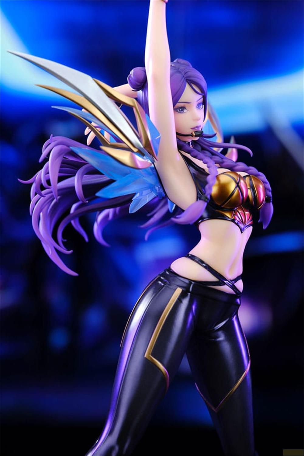 Figura de mujer con pelo morado, sujetador dorado y pantalones negros.