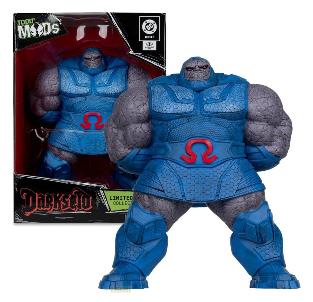 Eine Actionfigur von Darkseid in blauer Rüstung mit rotem Omega-Symbol. Steht vor seiner Verpackung.