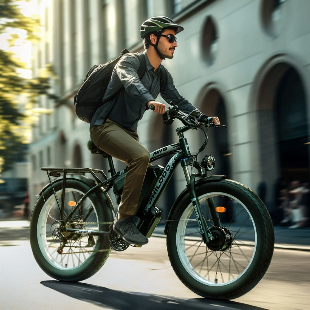 Hombre monta una bicicleta eléctrica por una calle con edificios.
