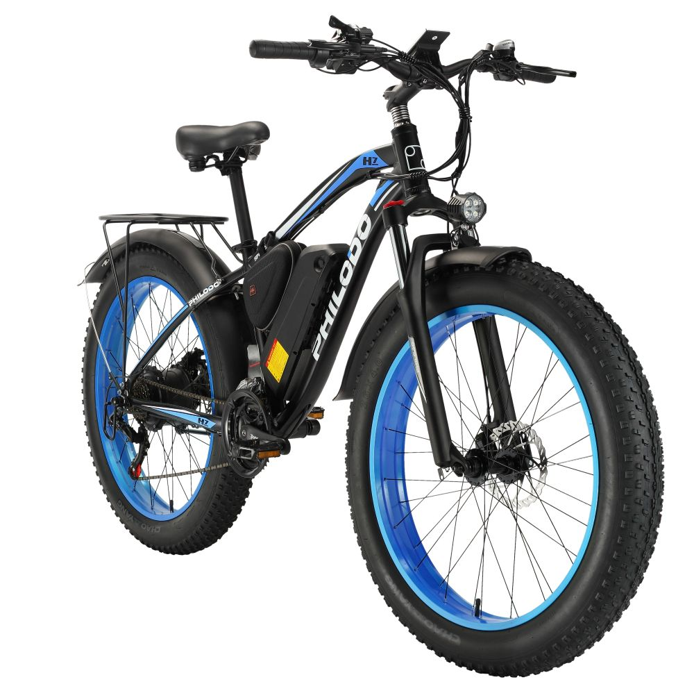 Bicicleta eléctrica negra con llantas gruesas y aros azules, luces delantera y trasera.