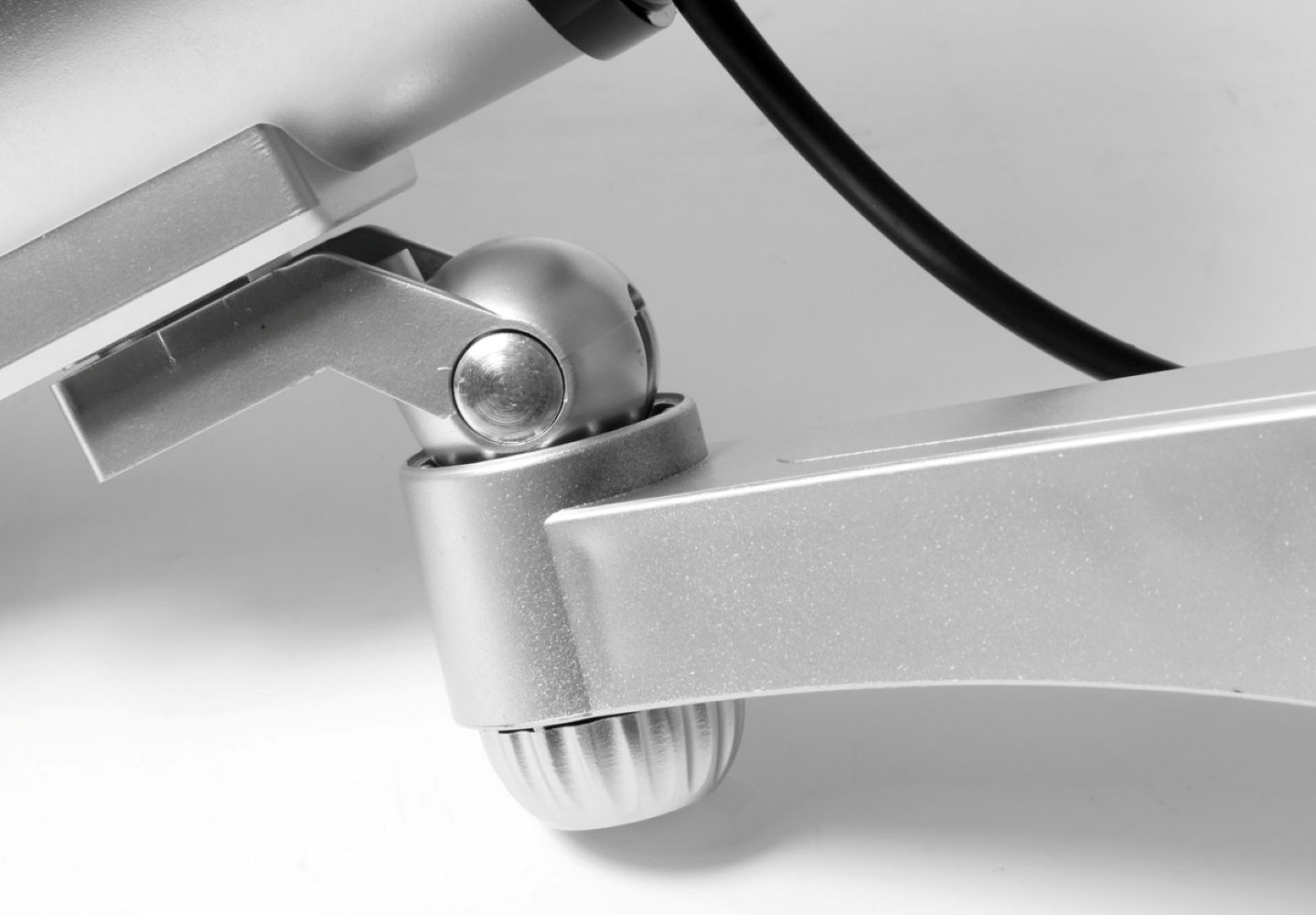 Zbliżenie srebrnego ramienia przegubowego z kablem.