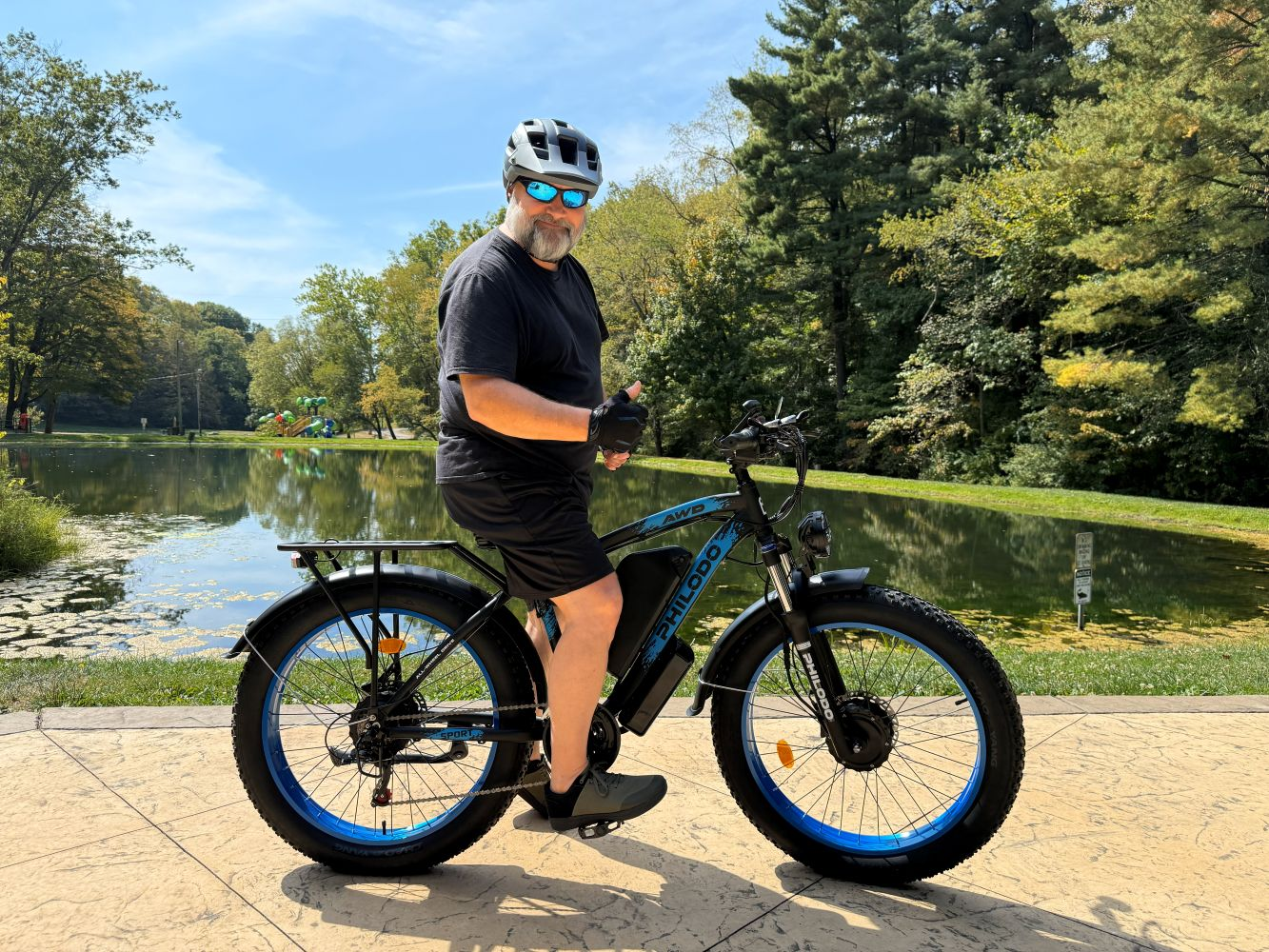 Hombre con casco y gafas de sol se sienta en una e-bike de llantas gordas.