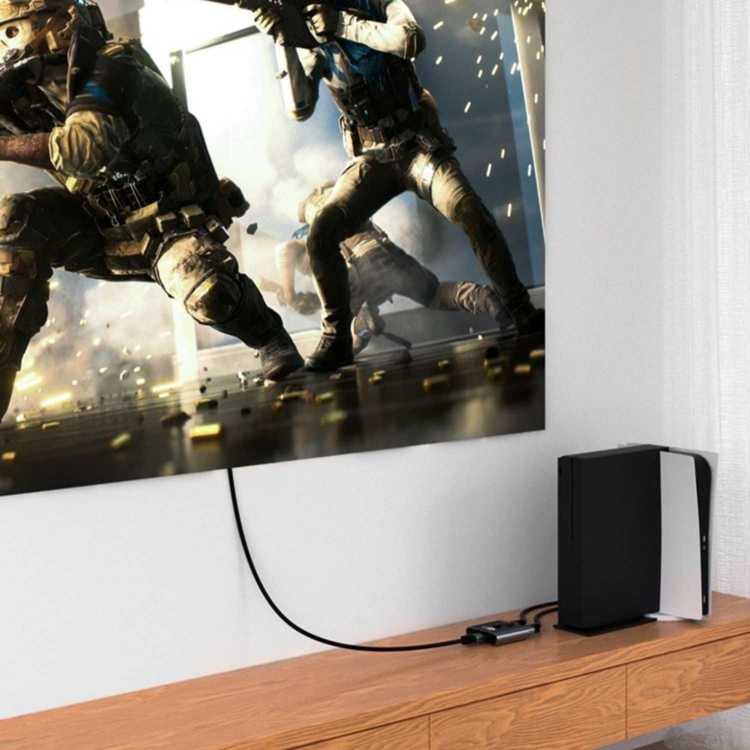 Zwei Soldaten spielen ein Videospiel auf einem großen Bildschirm, eine Konsole ist daneben.