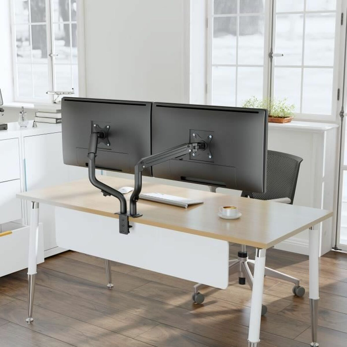 Due monitor su una scrivania con supporto a doppio braccio, tastiera, tazza e sedia.