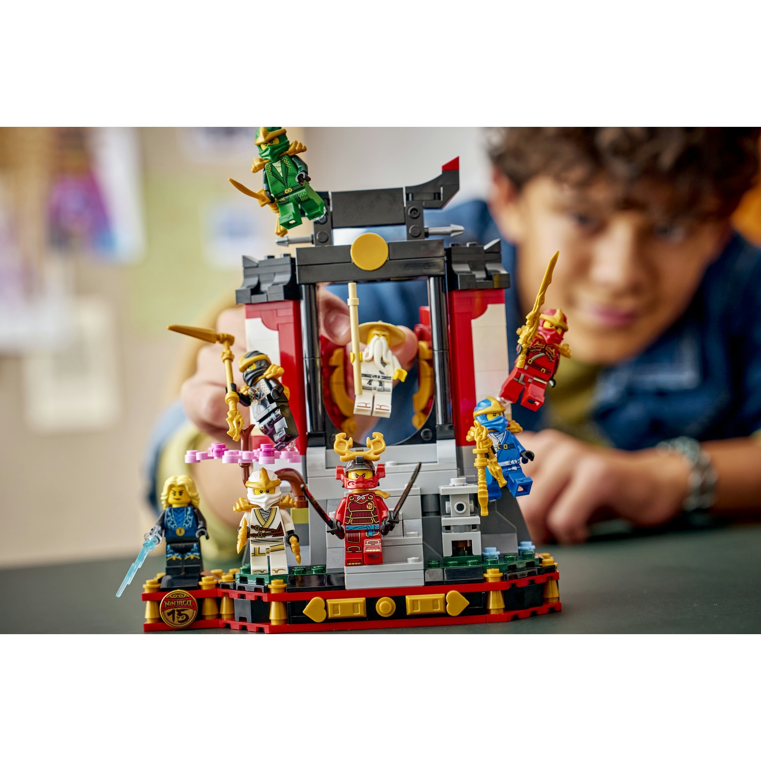 Figuras de Lego Ninjago en un set de construcción, sostenido por un niño.