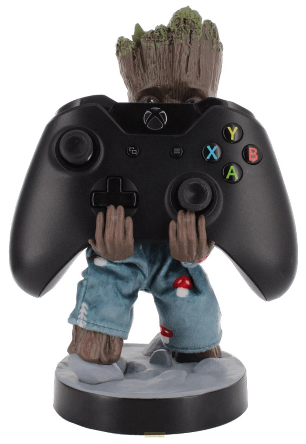 Baby Groot indossa pantaloni blu con stampe di funghi e tiene un controller Xbox nero.