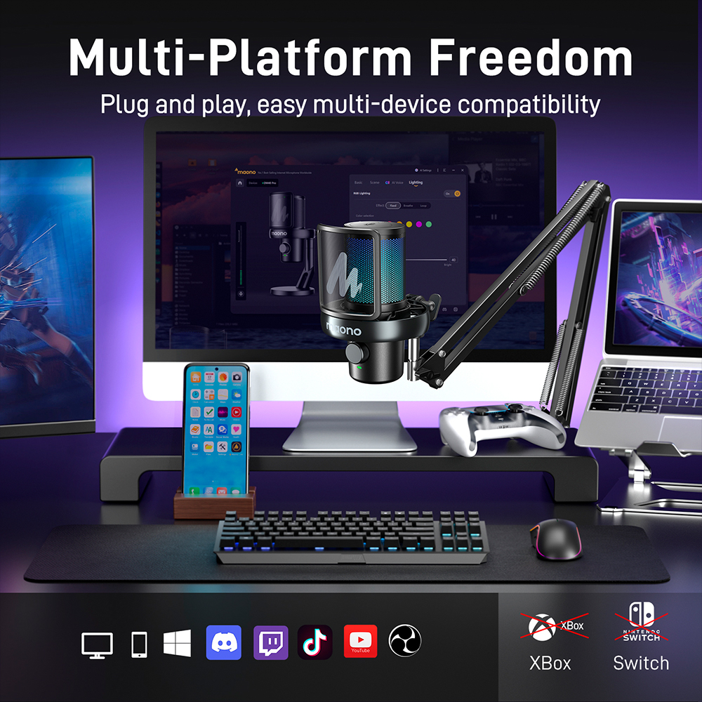 Un microphone, un PC, un téléphone, un ordinateur portable, une manette et un clavier sont disposés sur un bureau.