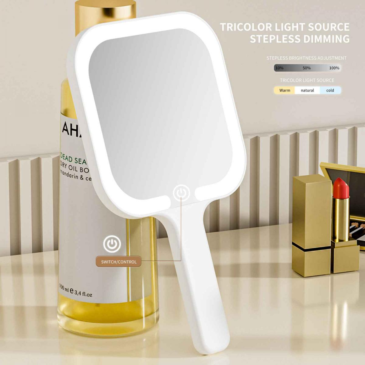 Ein weißer Hand-LED-Spiegel mit Ein-Aus-Taste, neben einer Ölflasche und Lippenstift auf einer weißen Oberfläche.