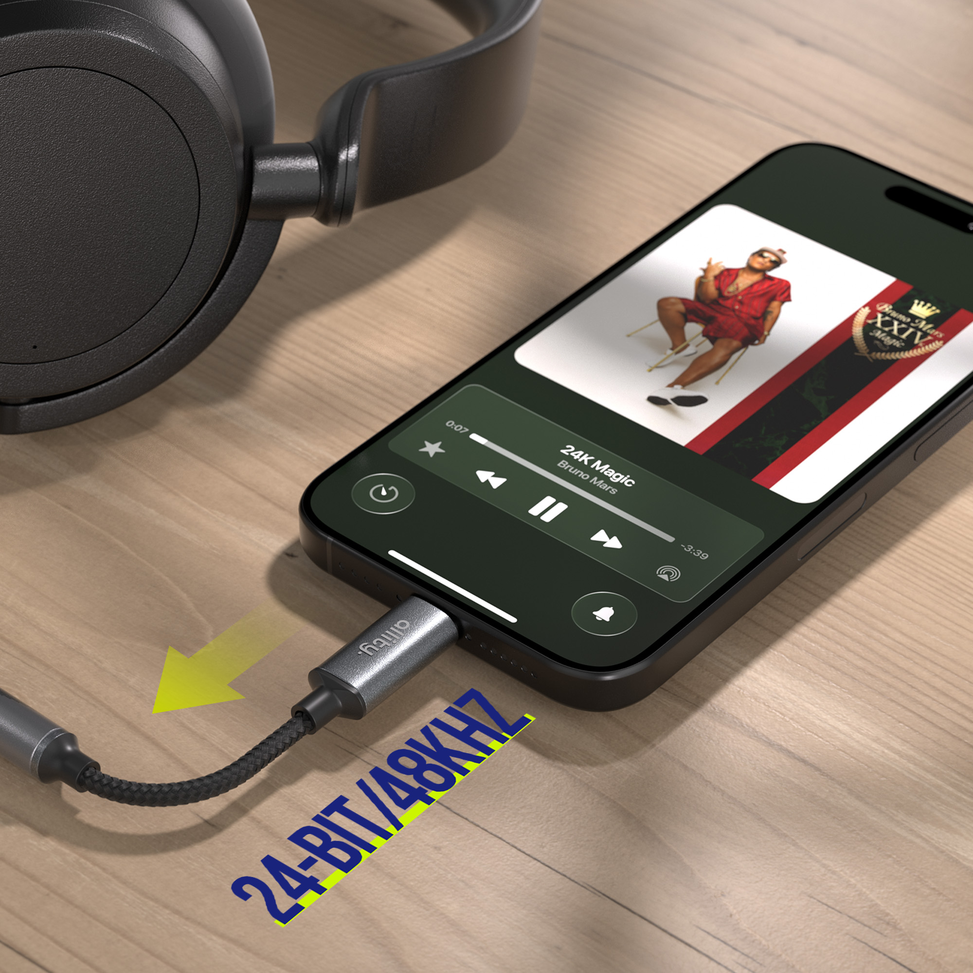 Czarne słuchawki podłączone do telefonu odtwarzającego "24K Magic" Bruno Marsa.