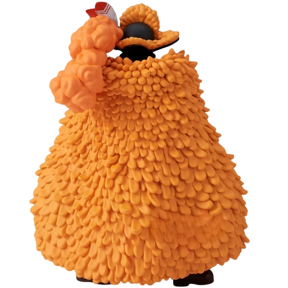 Una figura arancione con texture soffice e nastro rosso e bianco sulla testa.