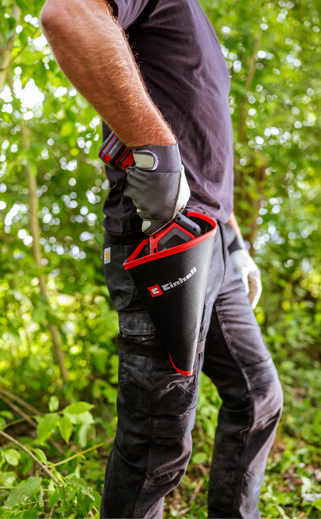 Mann mit Handschuhen hält Werkzeug in einem schwarzen Beutel mit rotem Rand.