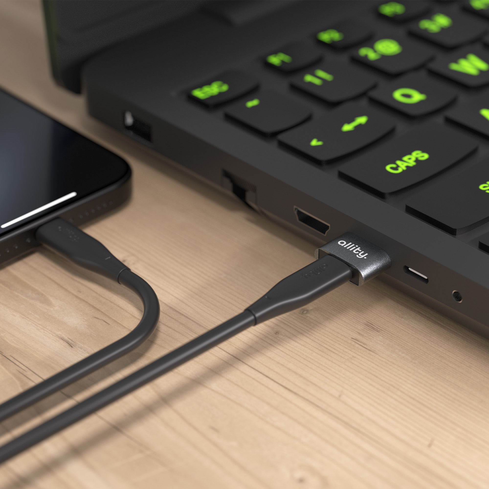 Czarny kabel ładujący łączy smartfon z laptopem.